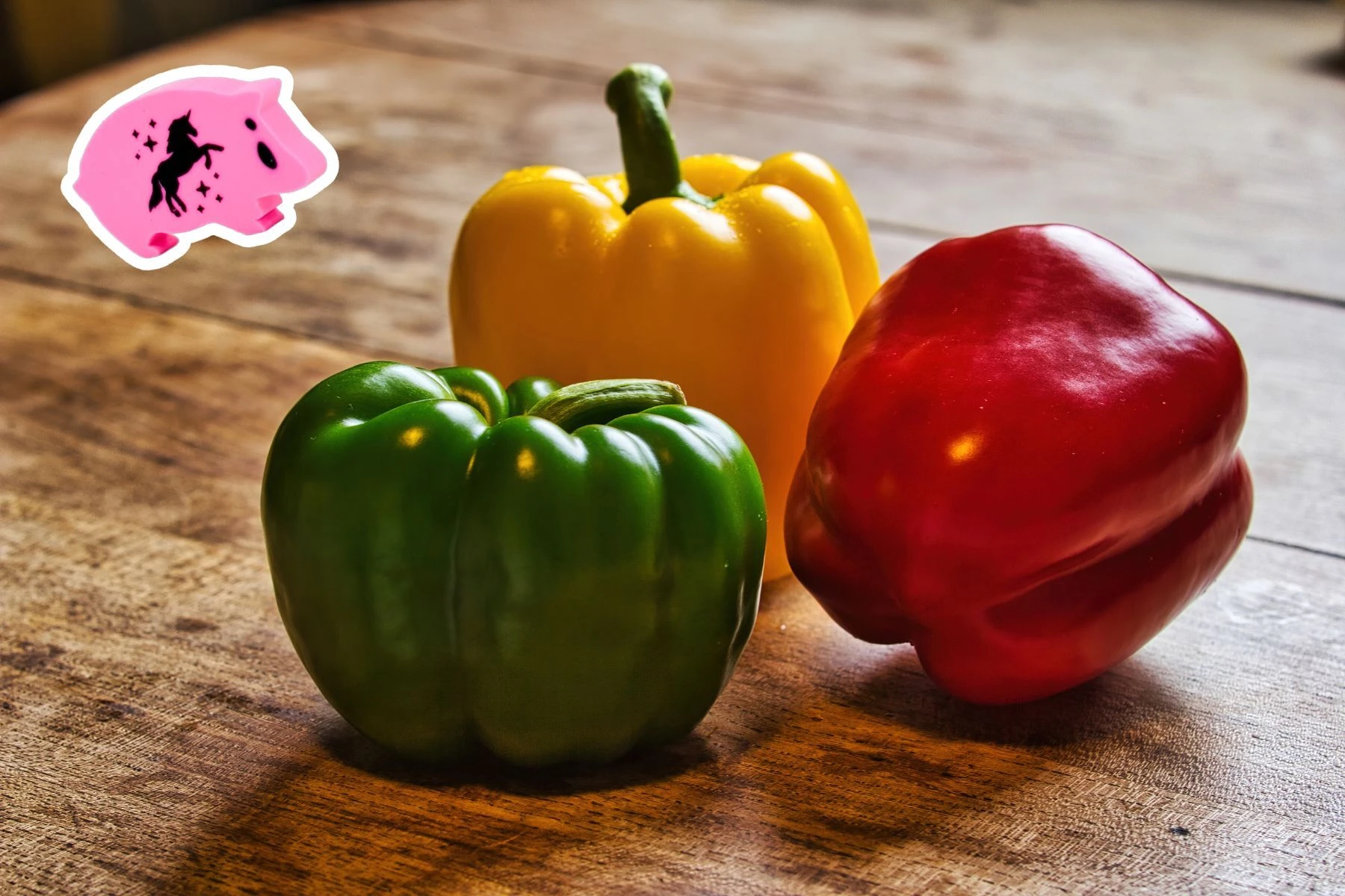 a unicorn age ham beside green, yellow and red peppers